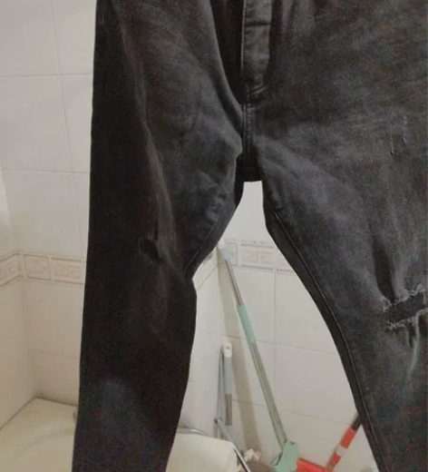 出一条黑色牛仔裤，品牌未知。裤子为修身款式...