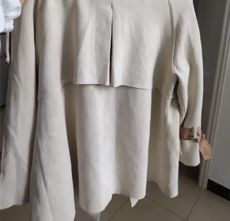 出一件白色宽松长袖风衣，适合春季穿着，款式...