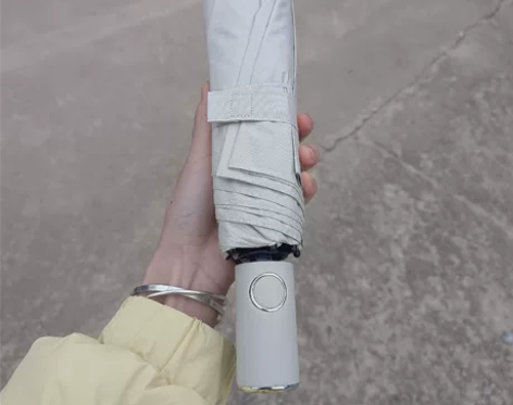 出白色全自动雨伞。伞面展开时直径约为1米，...