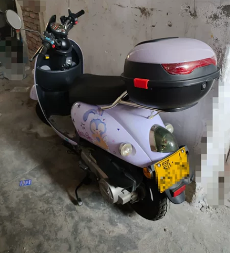 出一辆紫色踏板摩托车,车身成色很新,贴了星...