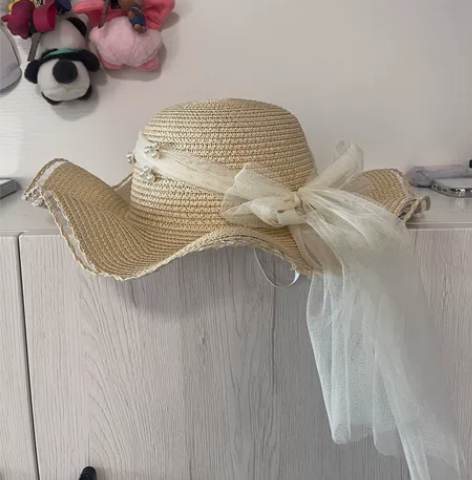 出一顶优雅的草帽，拥有米色的外观和精致的珍...