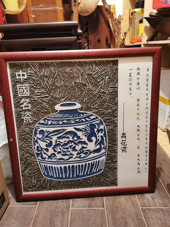 此为中国独有的瓷板雕刻画，雕刻一个青花瓷罐...