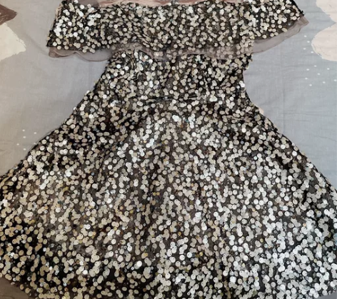 衣阁里拉亮片连衣裙，肩膀处是同色的网纱，有...